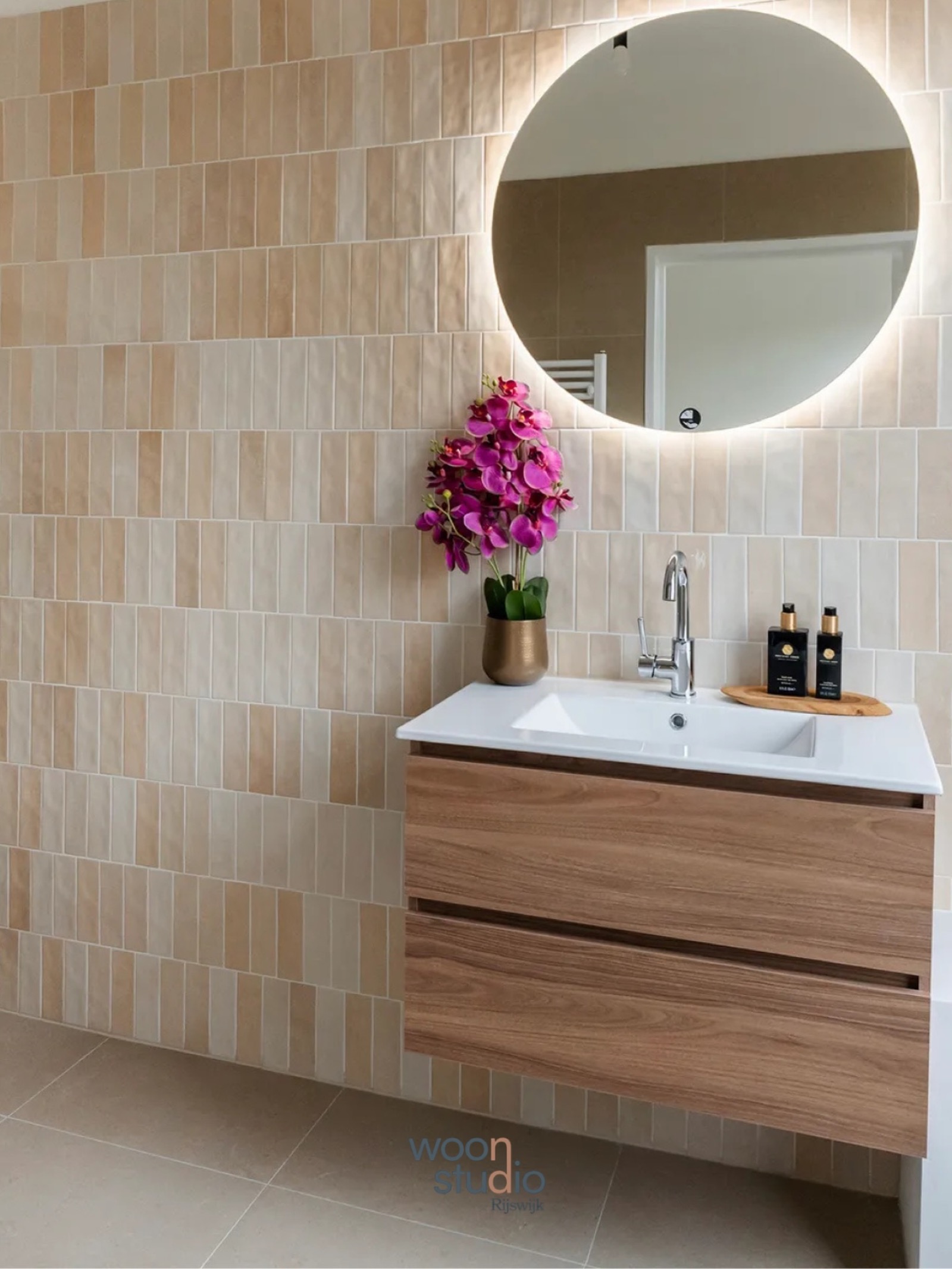 Een moderne badkamer waarin rust en warmte samenkomen.De verticale wandtegels, het hout...